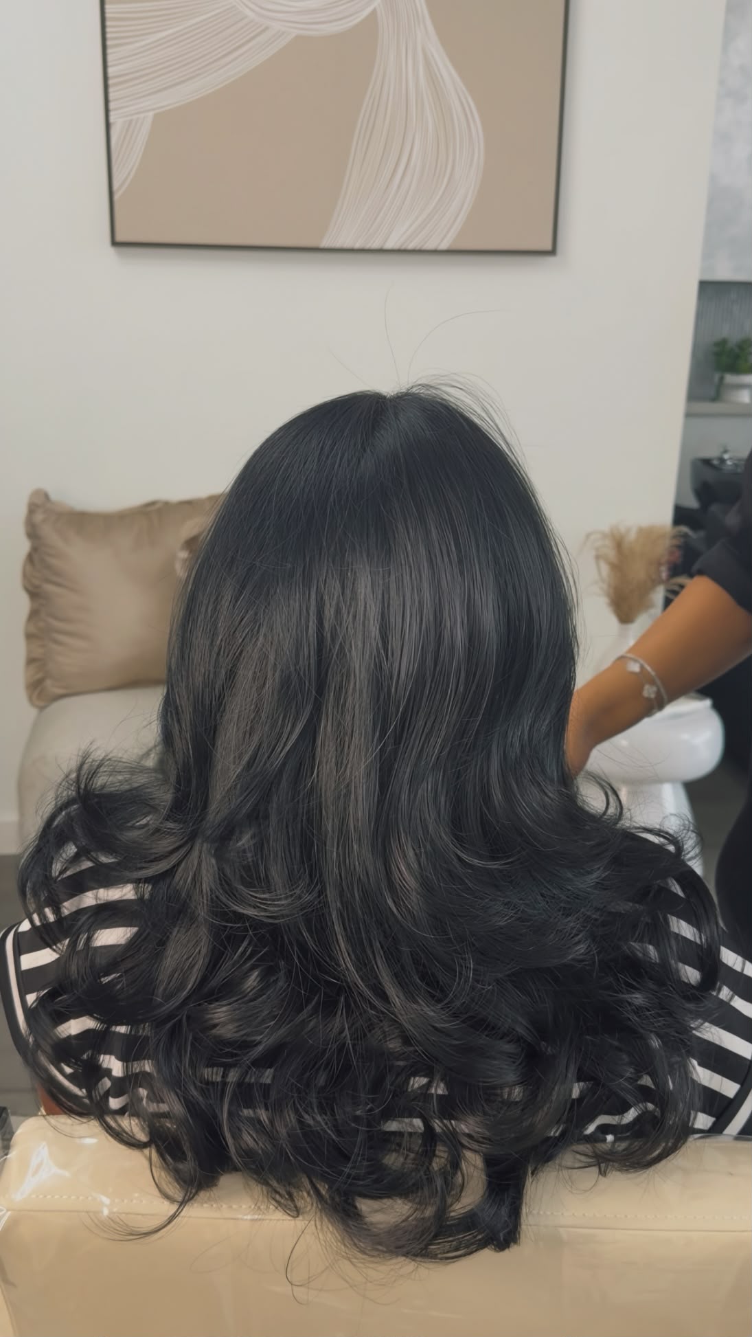 Glossy dark all-over hair color with a styled finish
